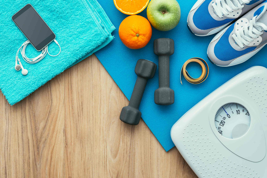 Sports-and-workout-equipment-on-a-wooden-floor-with-healthy-snacks